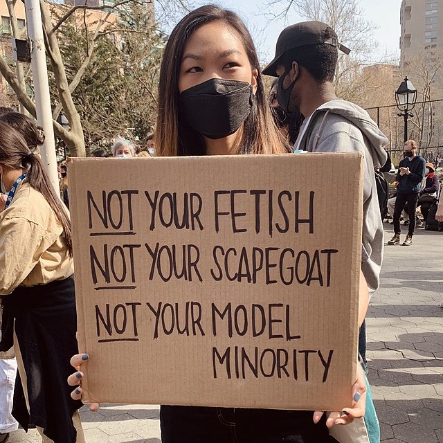 A protestor during the Rally for Asian American Women holding a sign saying "NOT your fetish, NOT your scapegoat, NOT your model minority"
